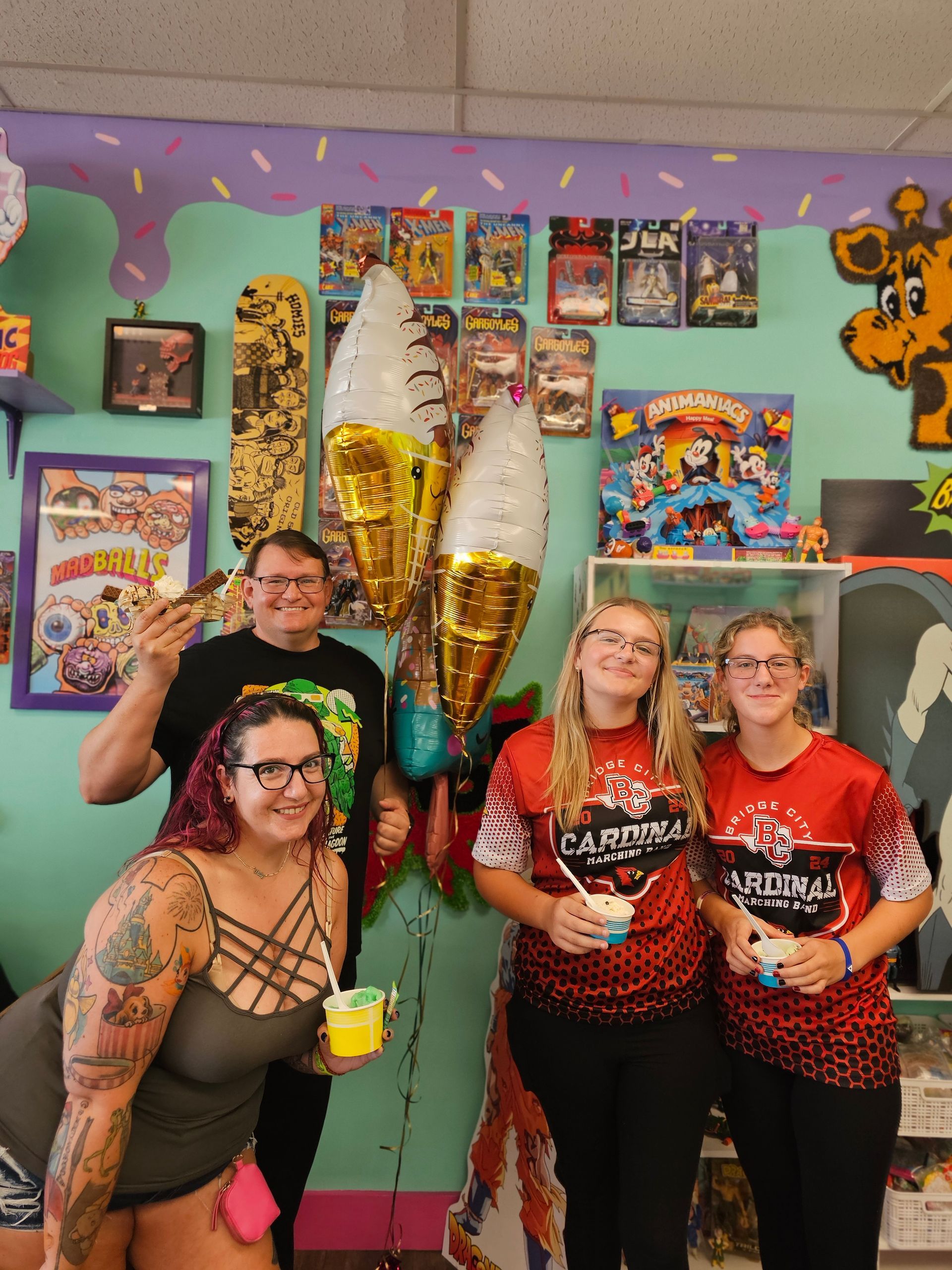 A group of people standing next to each other in a room holding balloons.