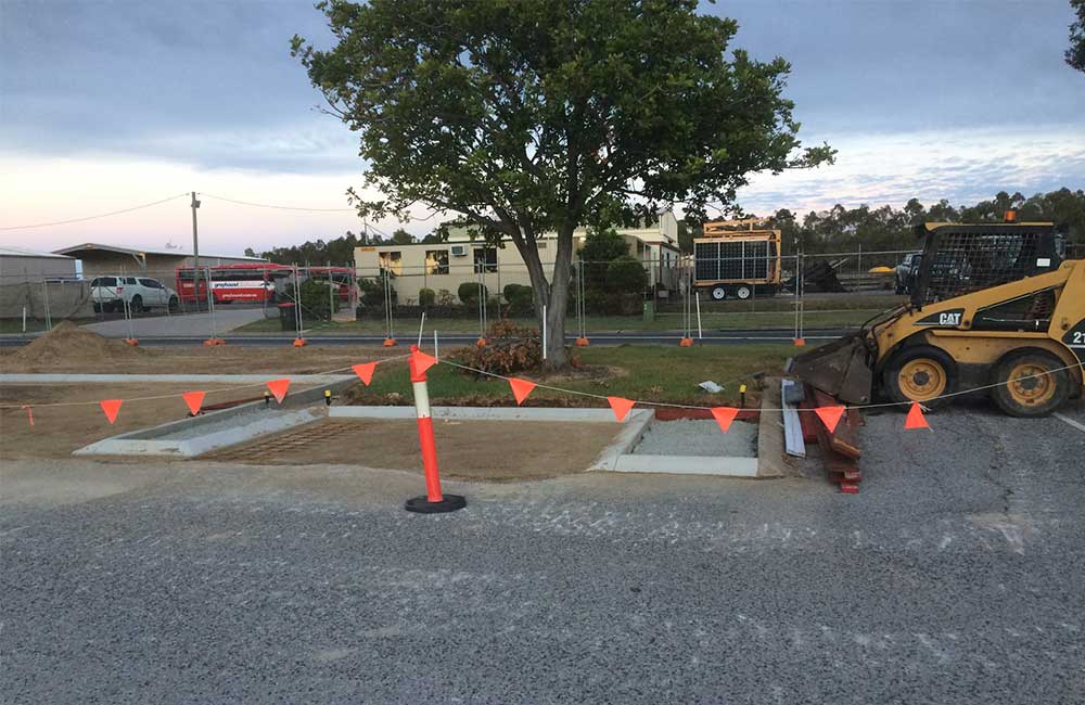 An Earthmover Working in a Parking Lot — Civil Construction in Gladstone Region, QLD