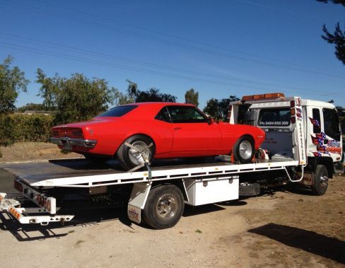 An red car being towed by towing services in the Barossa valley