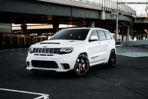 A white dodge ram truck is parked in front of a building.