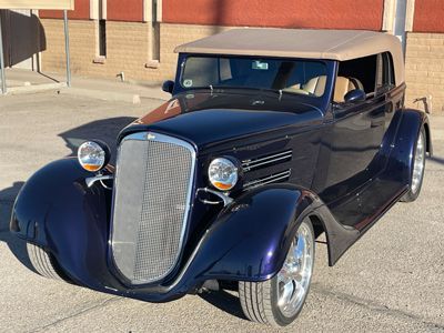 A black vintage car is parked in front of a building.