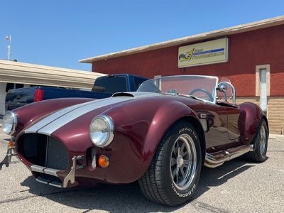 A red and white sports car is parked in front of a building.