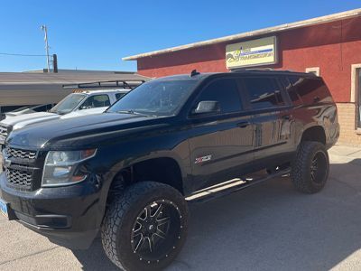 A black suv is parked in front of a red building.