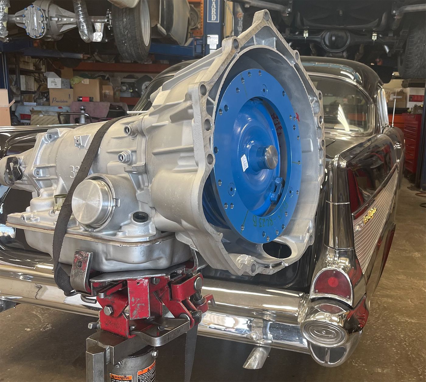 A car with a blue wheel is being lifted by a jack.