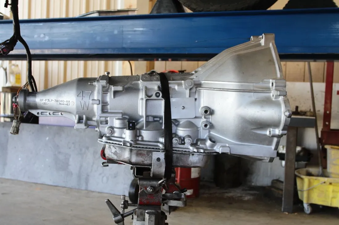 Large silver aircraft engine on a stand in an industrial workshop