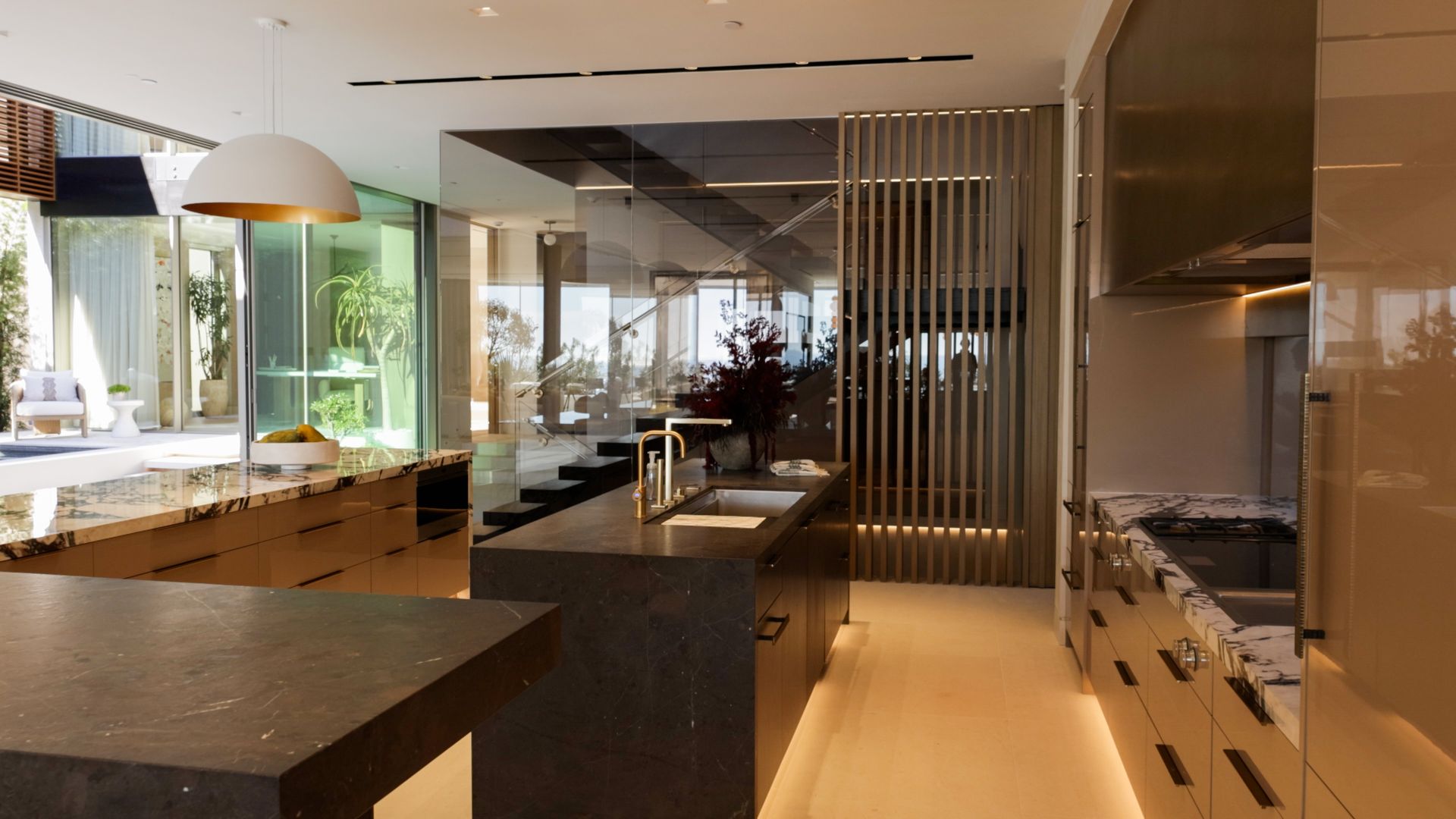 Modern white house exterior at dusk with a swimming pool, glowing landscape lighting, and patio seating on synthetic turf.