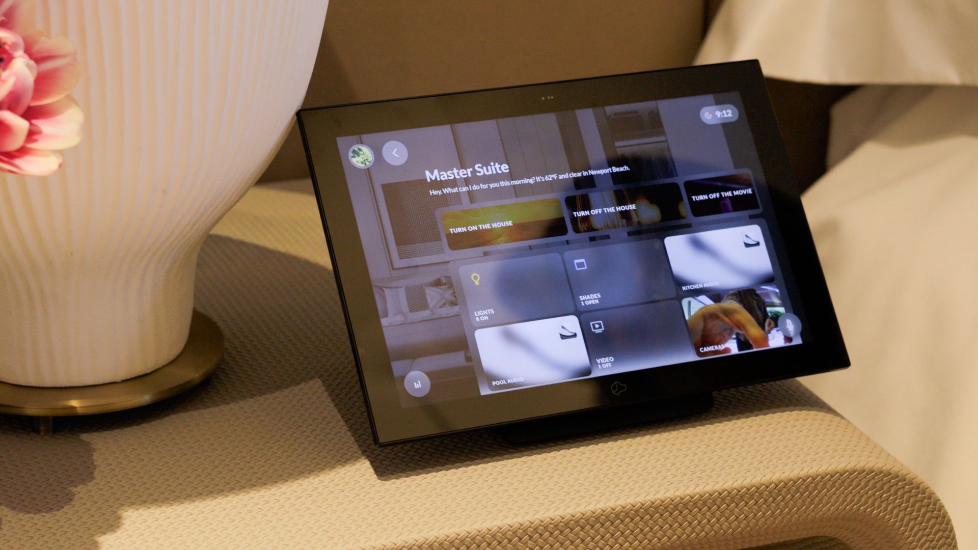 Modern white house exterior at dusk with a swimming pool, glowing landscape lighting, and patio seating on synthetic turf.