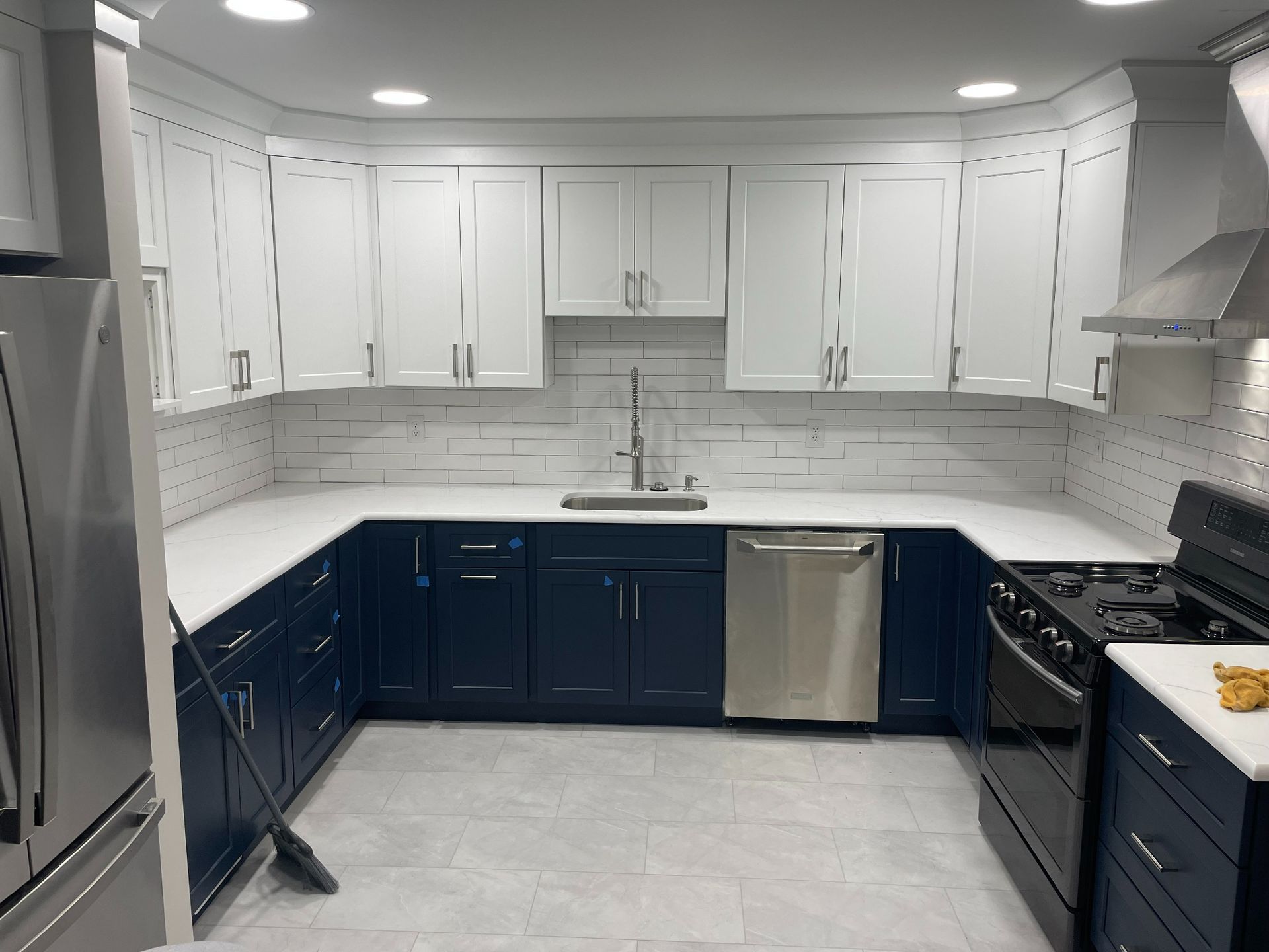 A walk-in shower with marble-look walls, a horizontal decorative mosaic tile band, a built-in niche, and a stone bench.