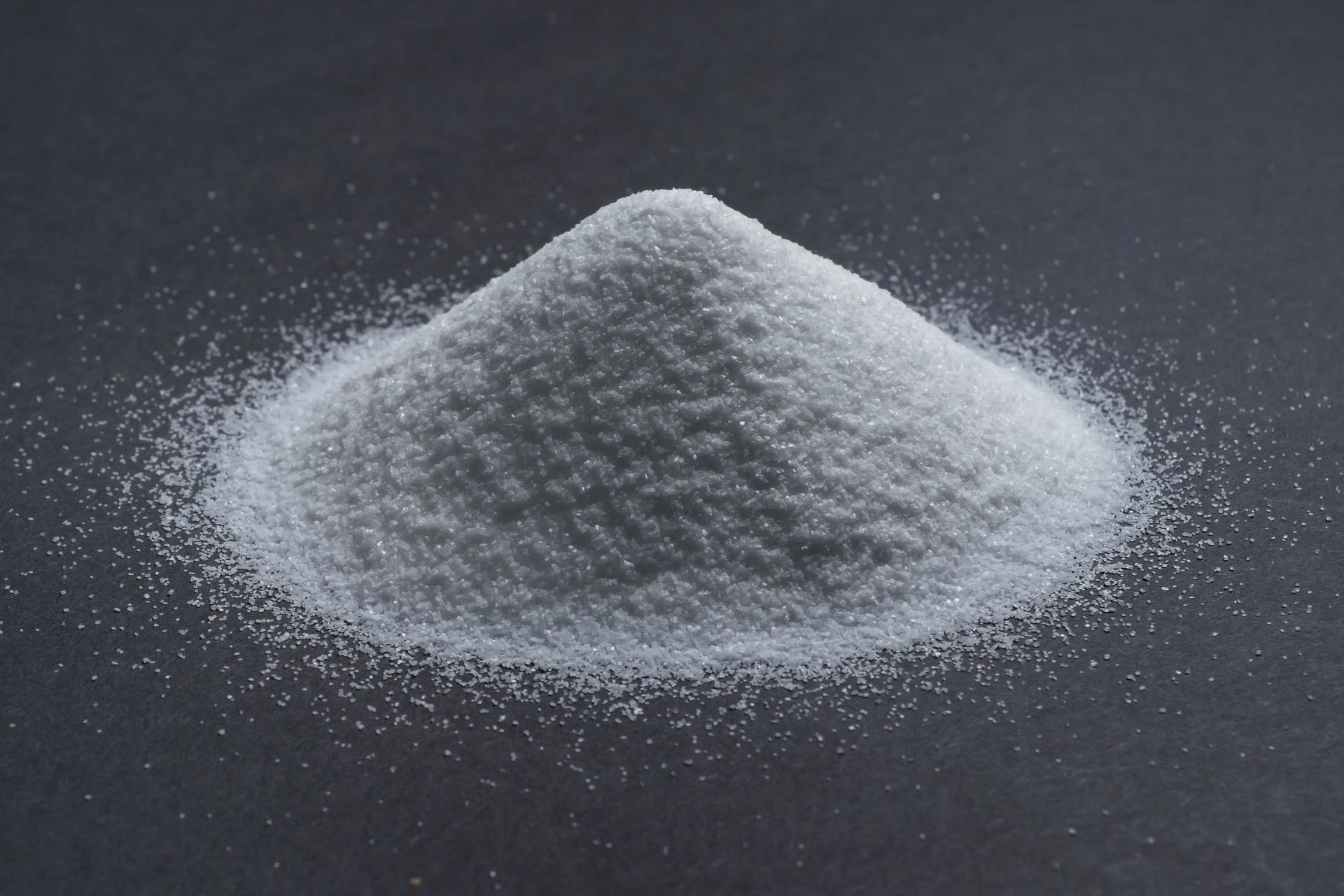 White powder piled in a small mound on a dark surface