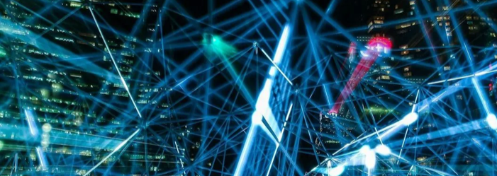 Blue glowing network over a cityscape at night, connecting points of light.