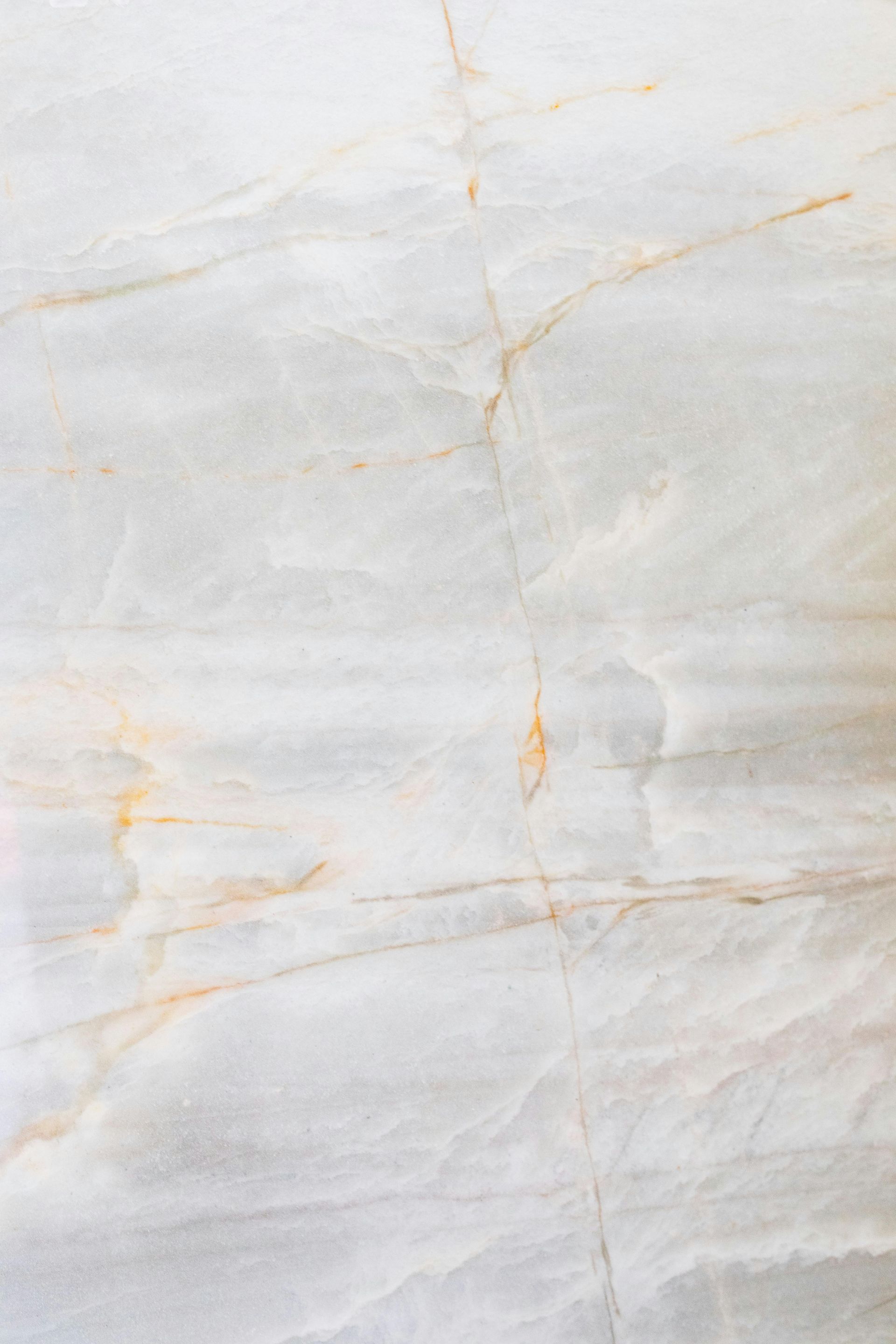 White and gray marble background with subtle gold veining.