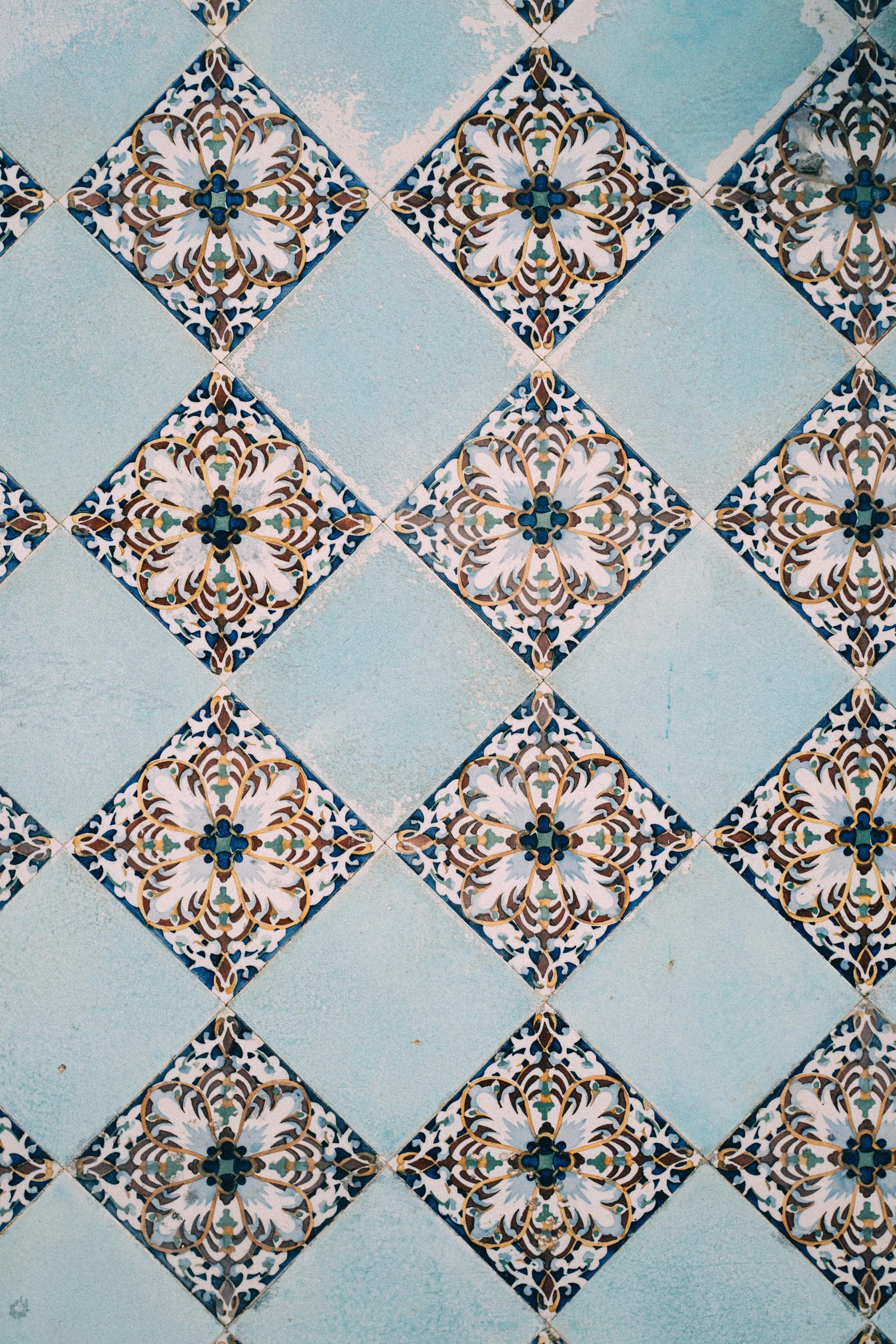 Diamond-patterned tiles in blue and white, with ornate floral designs and light blue filler tiles.