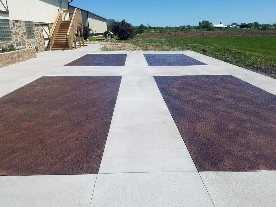 A concrete driveway with a cross design on it