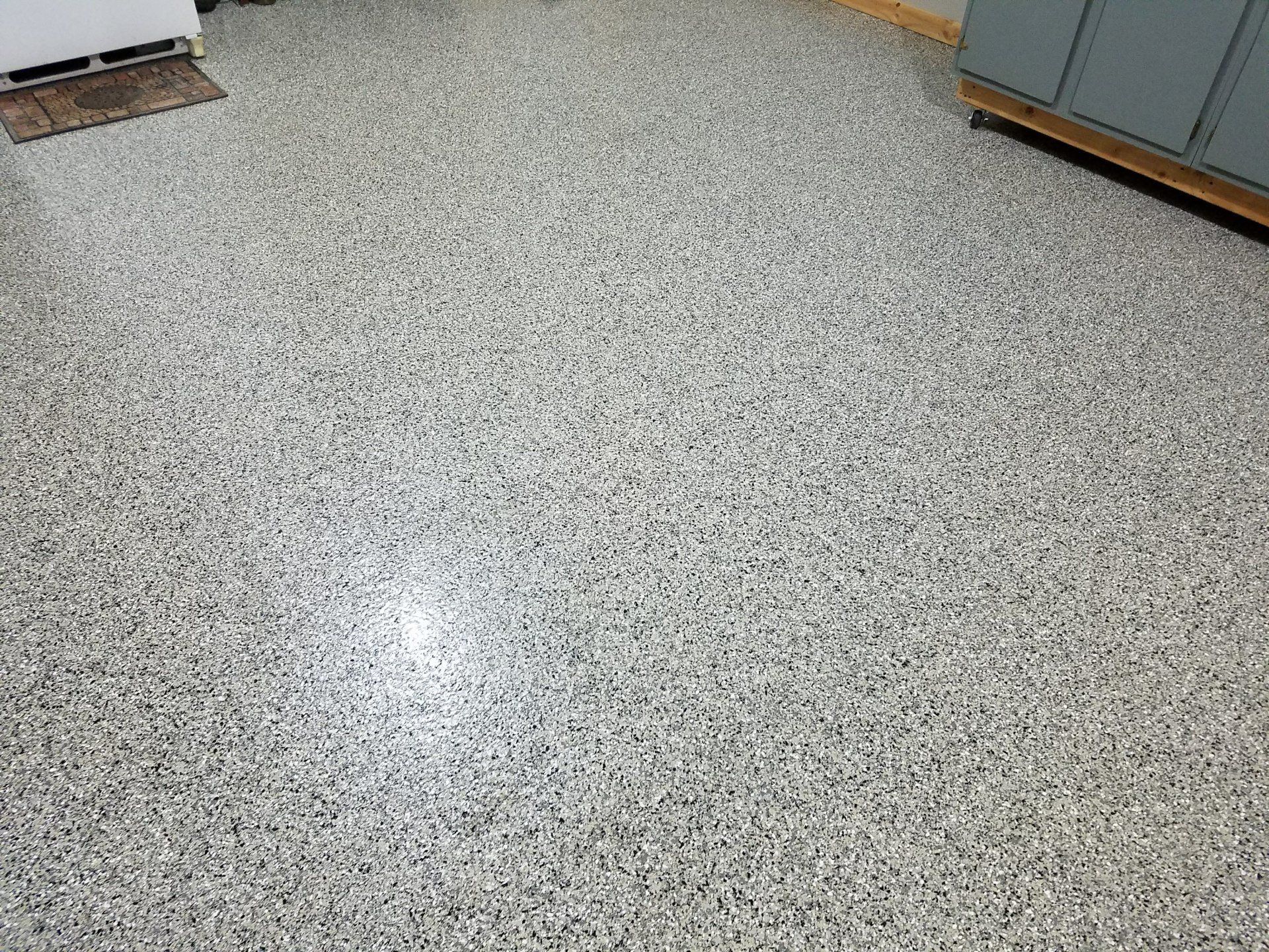 A kitchen floor with a lot of small stones on it.