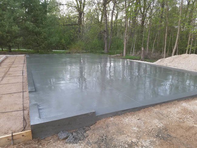 A concrete foundation is being built in the middle of a forest.