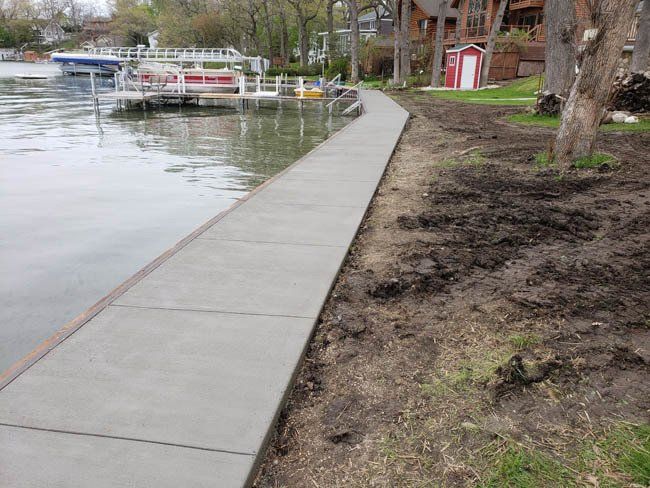 A concrete walkway next to a body of water