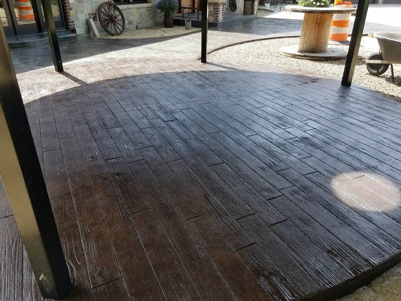 A wooden floor with a wheelbarrow in the background