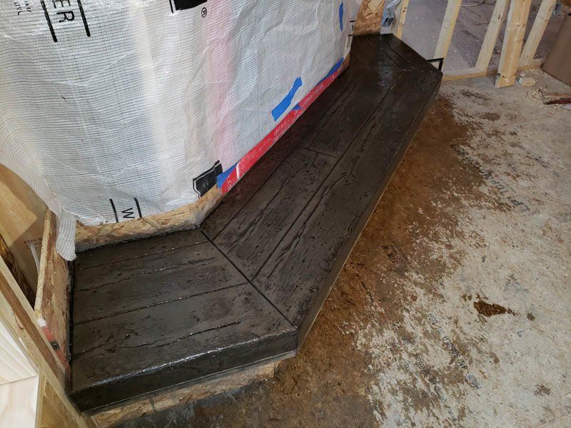 A wooden bench is sitting in a room next to a wall.