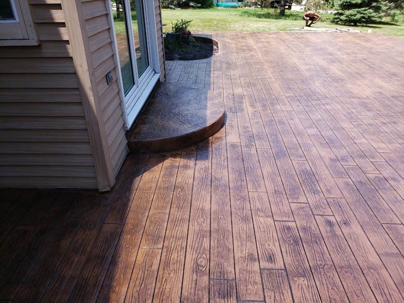 A wooden deck with a house in the background