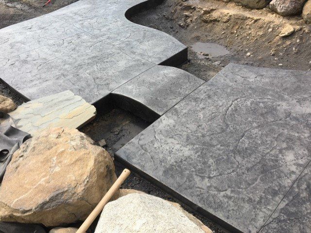 A concrete walkway is being built next to rocks.