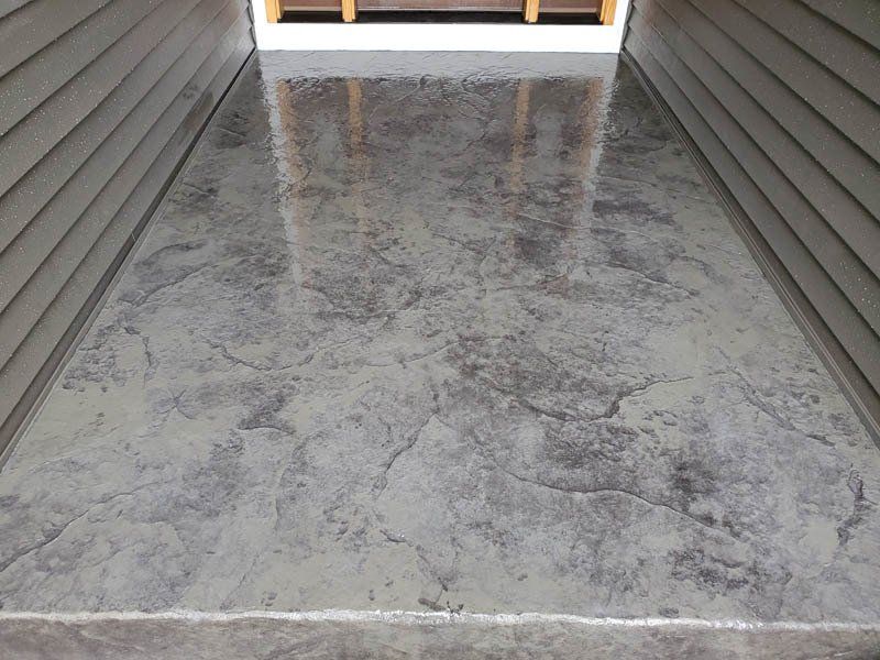A concrete floor with a marble texture and a staircase in the background.