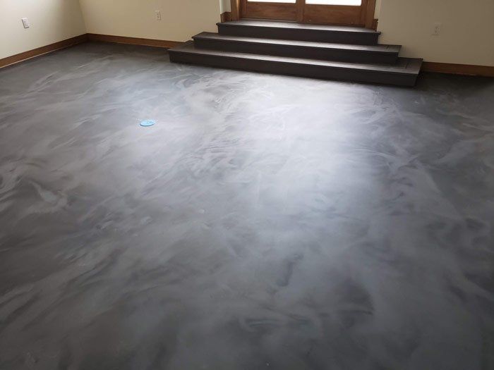 A room with a concrete floor and stairs in it