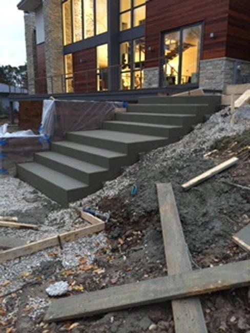 A concrete staircase is being built in front of a house.