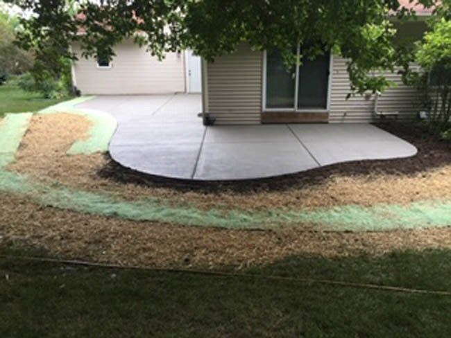 A concrete patio is being built in front of a house.