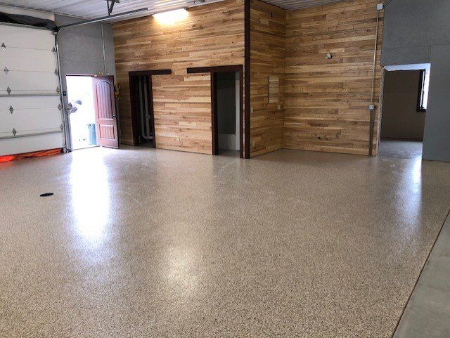 A large empty garage with a wooden wall and a concrete floor.