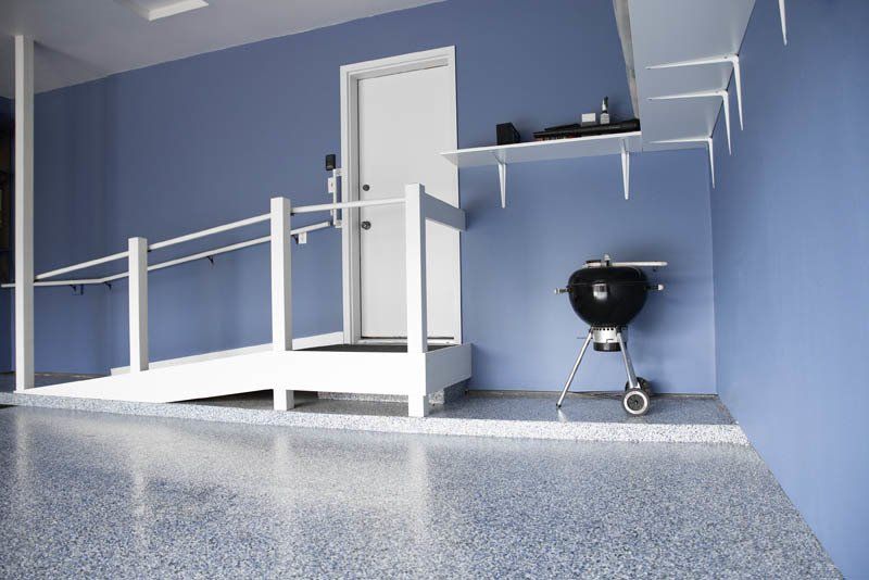 A blue garage with a ramp and a grill