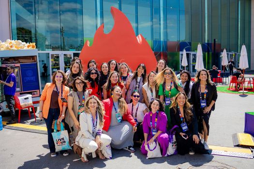 Um grupo de mulheres está posando para uma foto em frente a um prédio.