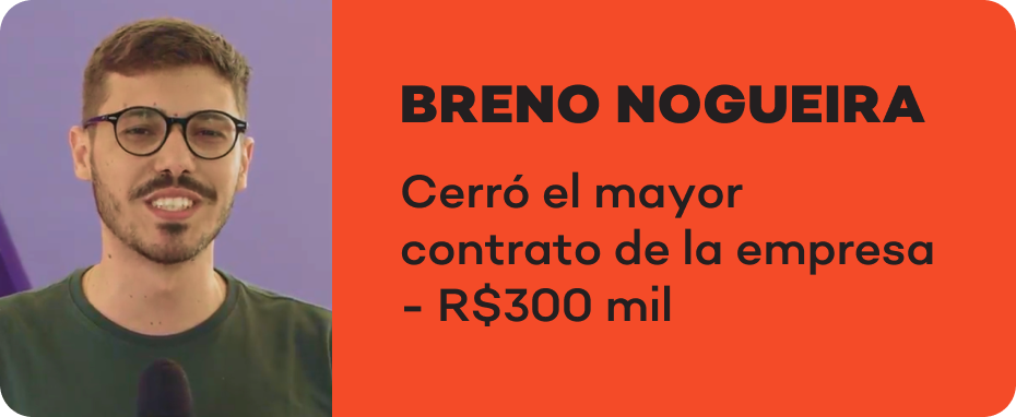 Um homem de óculos e barba está em pé na frente de um microfone.