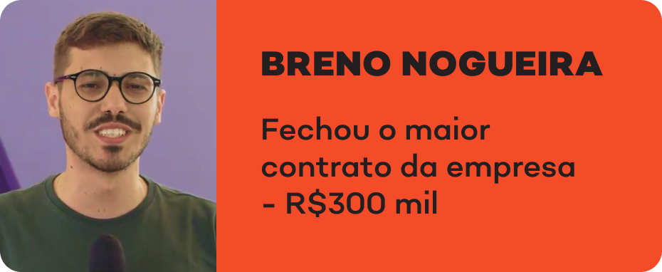 Um homem de óculos e barba está em pé na frente de um microfone.