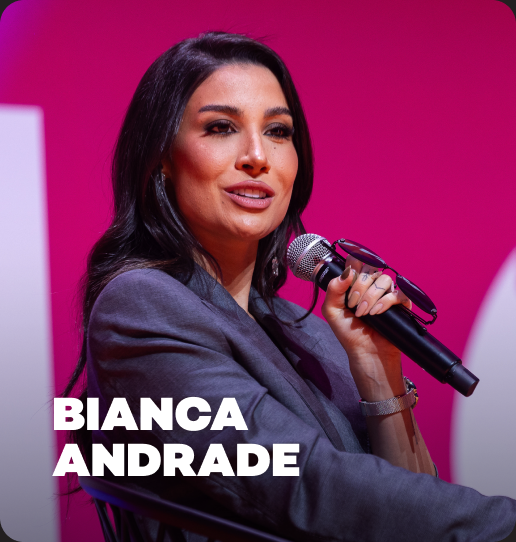 Bianca andrade está segurando um microfone em frente a um fundo rosa