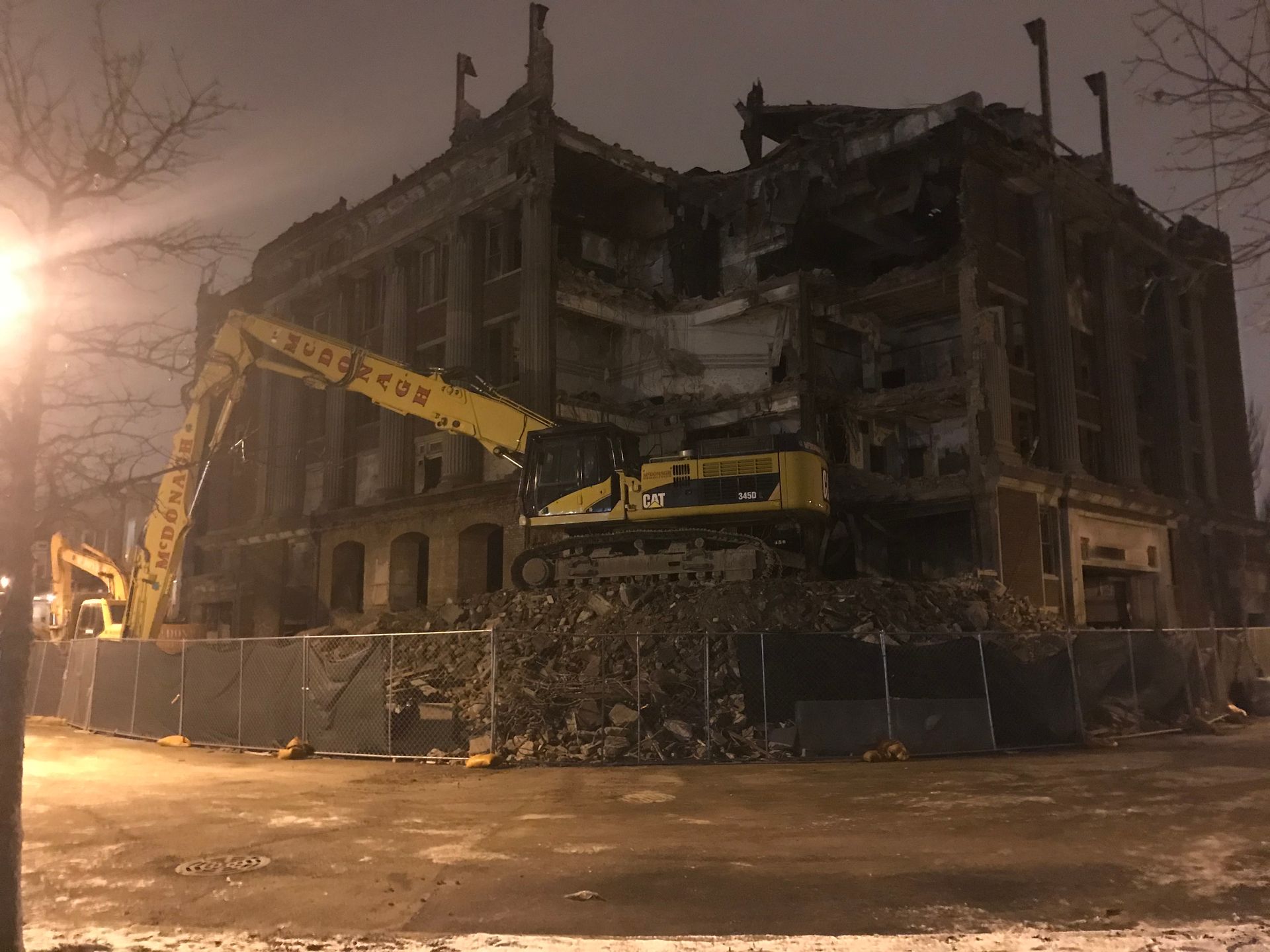 A large building is being demolished at night.