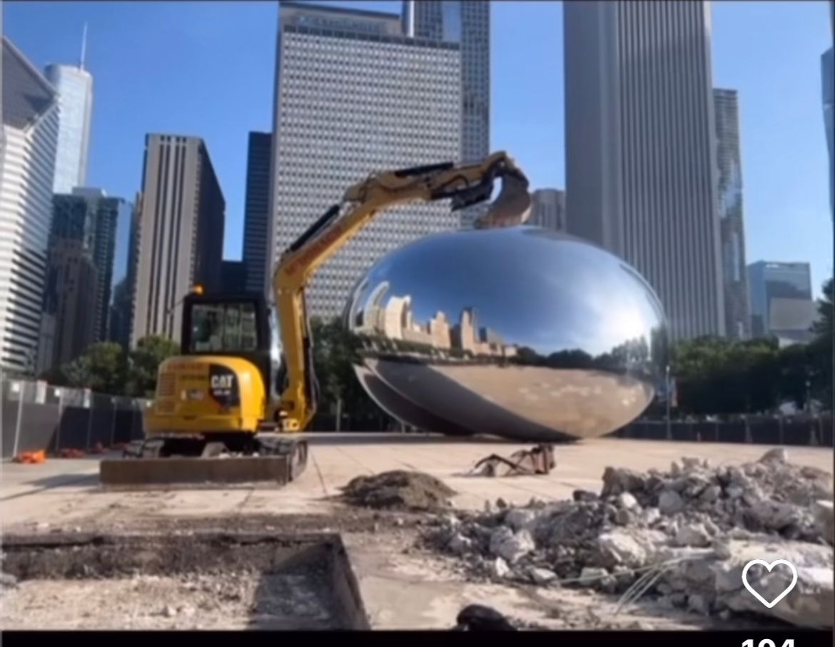 A large metal sculpture is being demolished by a bulldozer