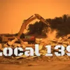 A bulldozer is demolishing a building on a construction site.