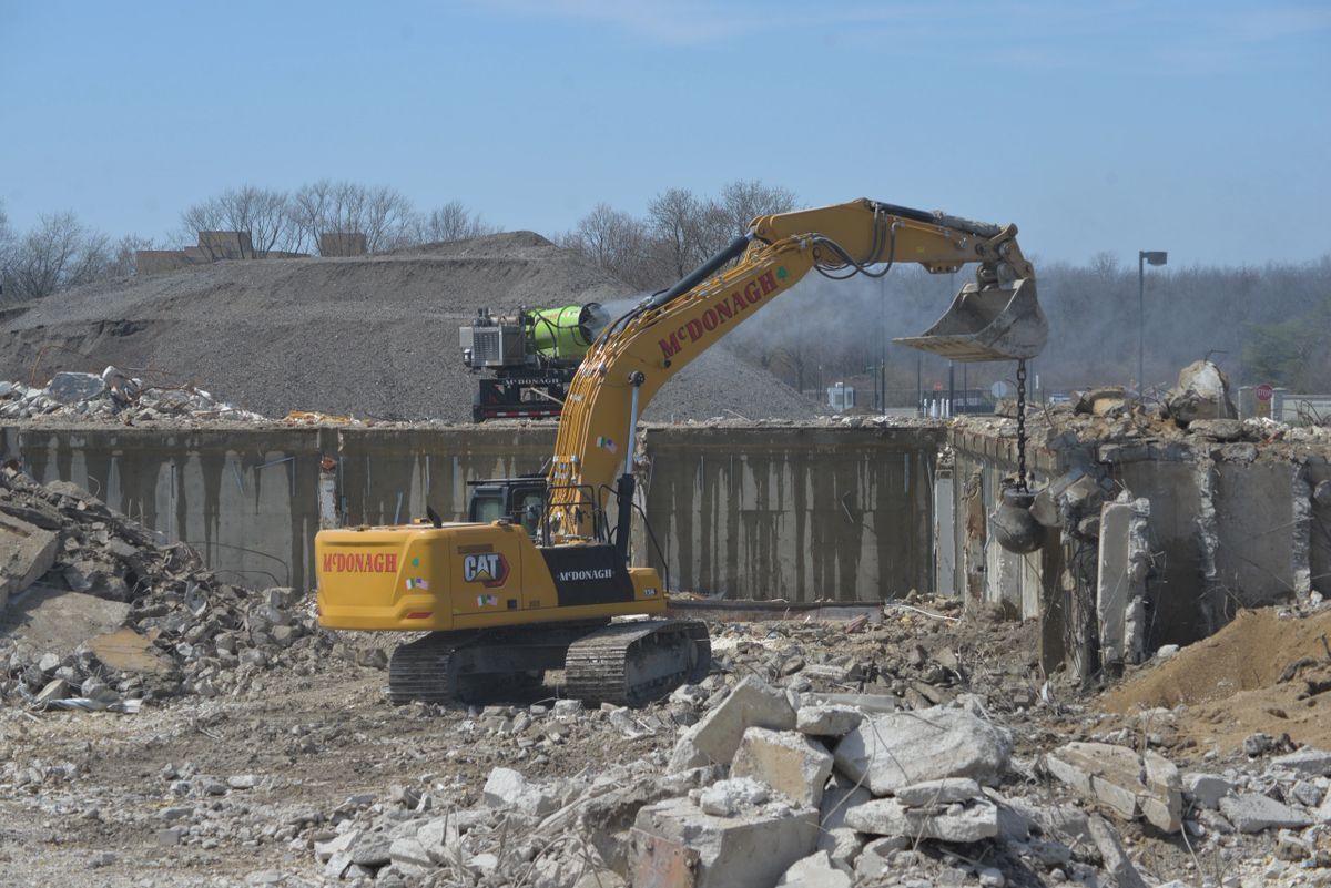 A yellow excavator is working on a construction site.