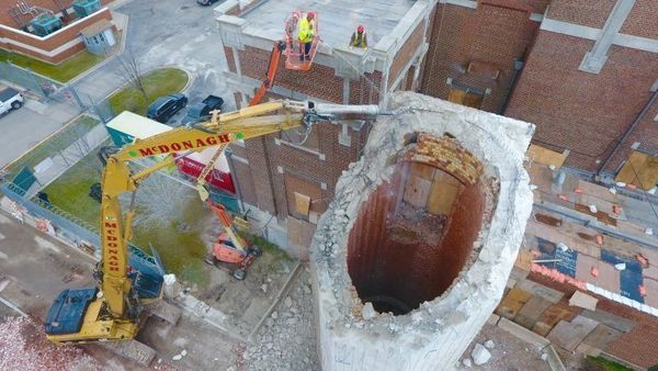 An aerial view of a construction site with a yellow excavator.