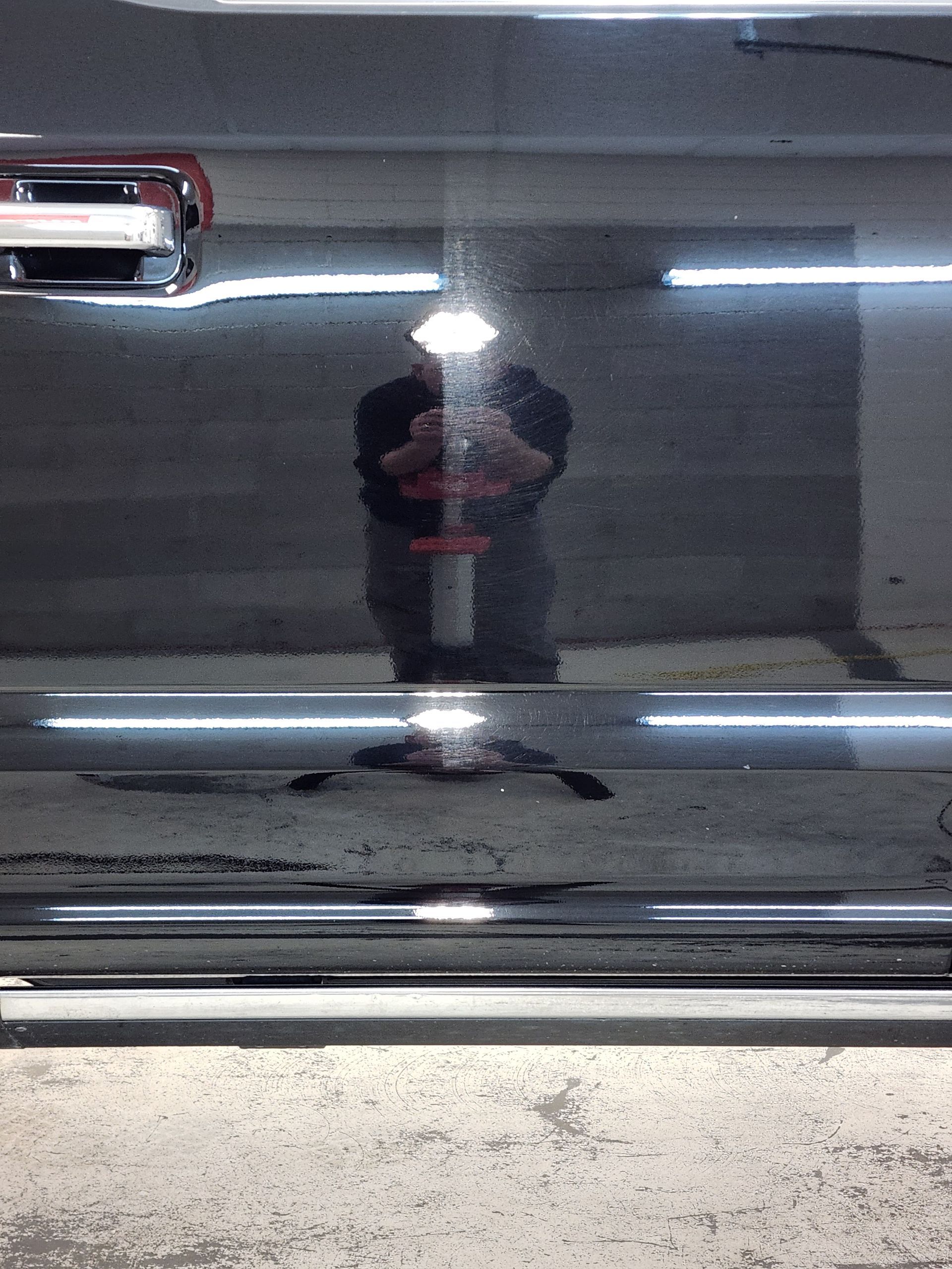 A man is taking a picture of himself in the mirror of a car