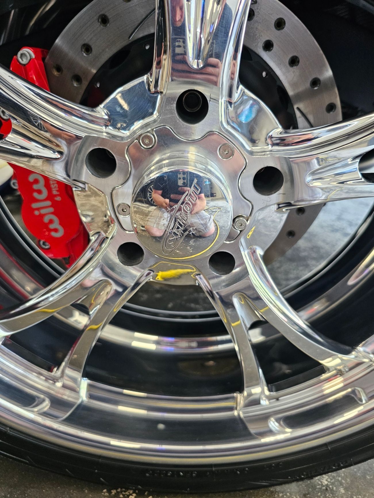 A close up of a motorcycle wheel with a red brake caliper