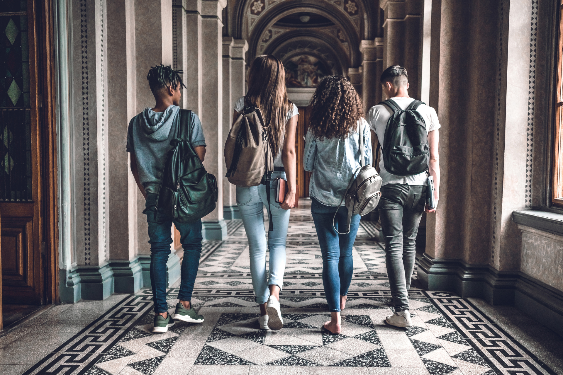 A group of people are walking down a hallway.