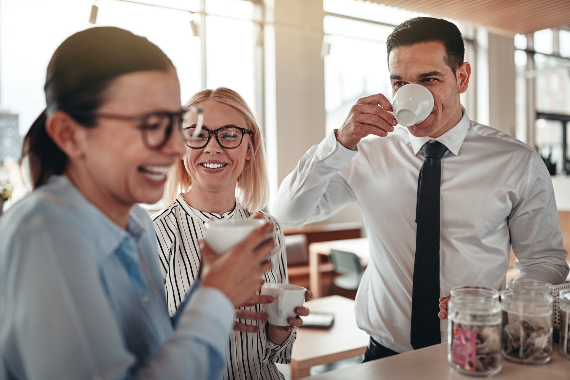 A group of people are drinking coffee together in an office.