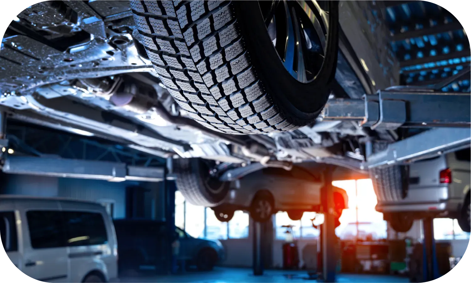 The underside of a car is being worked on in a garage.