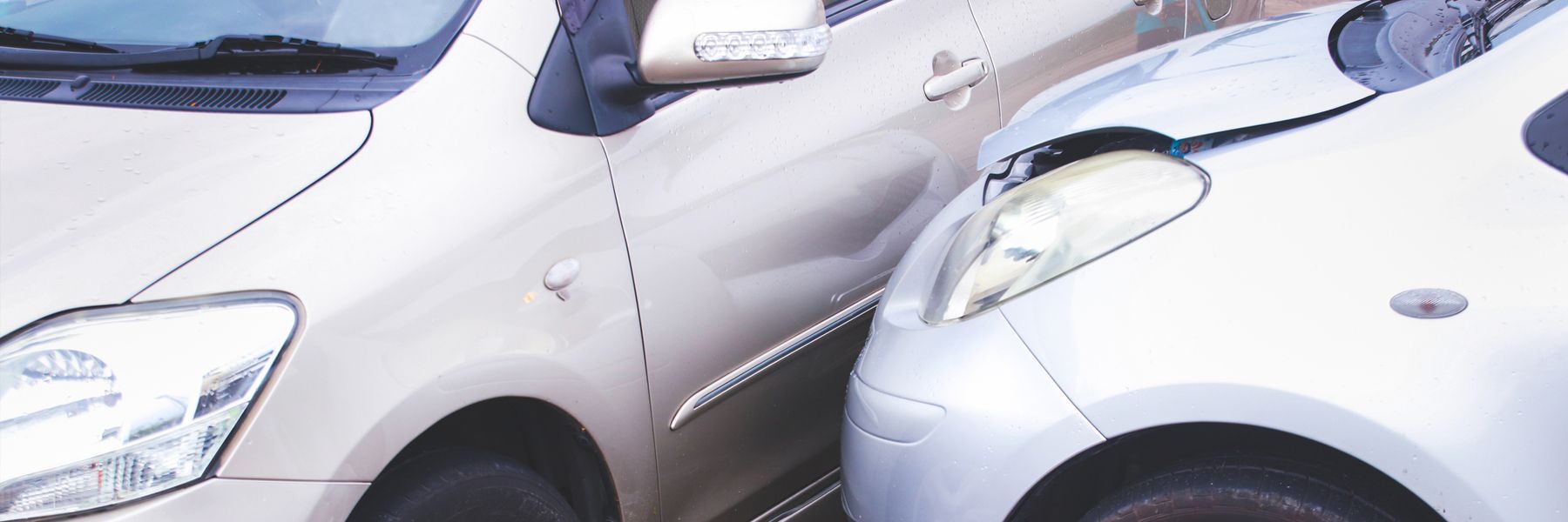 Two cars are parked next to each other on a street.