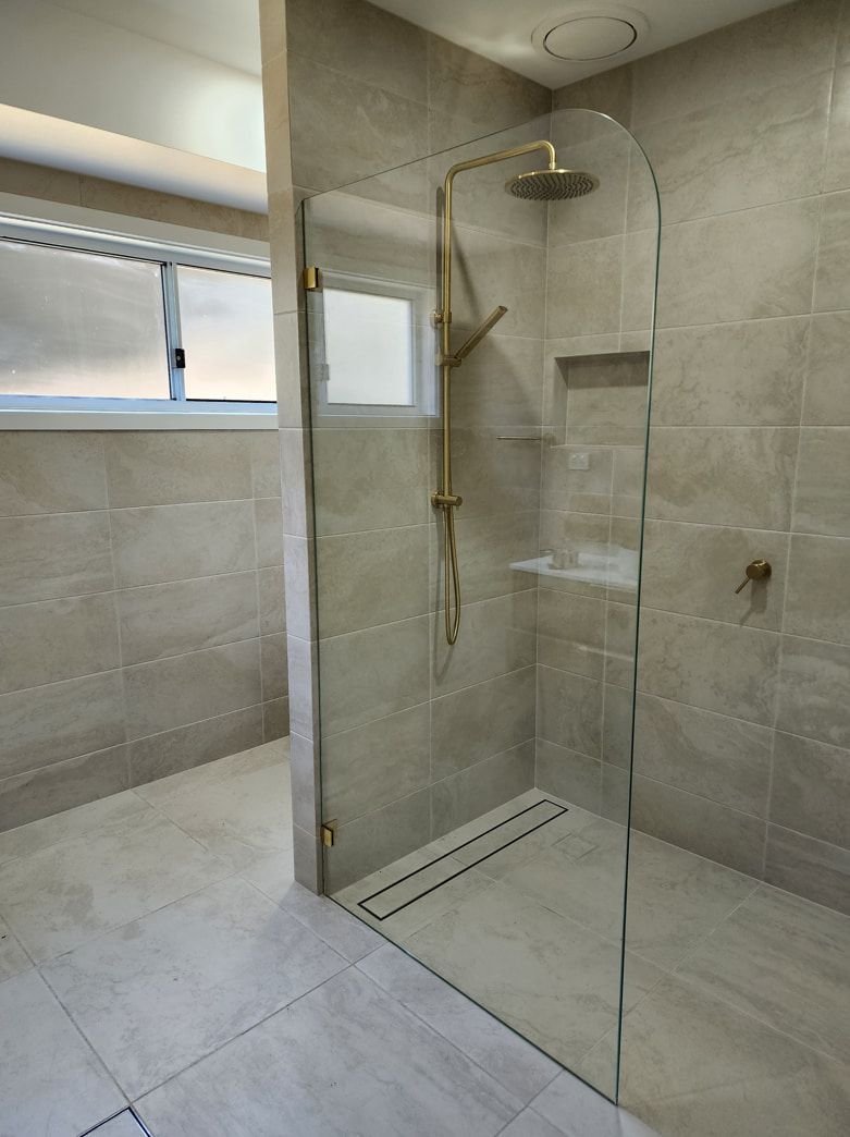A Bathroom With A Walk In Shower And A Window — Lumba Glass & Glazing In Kincumber, NSW