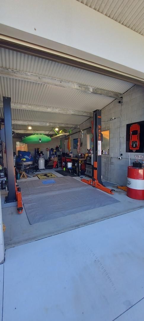 A Garage with A Car on A Lift in It — Coastal Mechanical Servicing and Repairs in Wurtulla, QLD