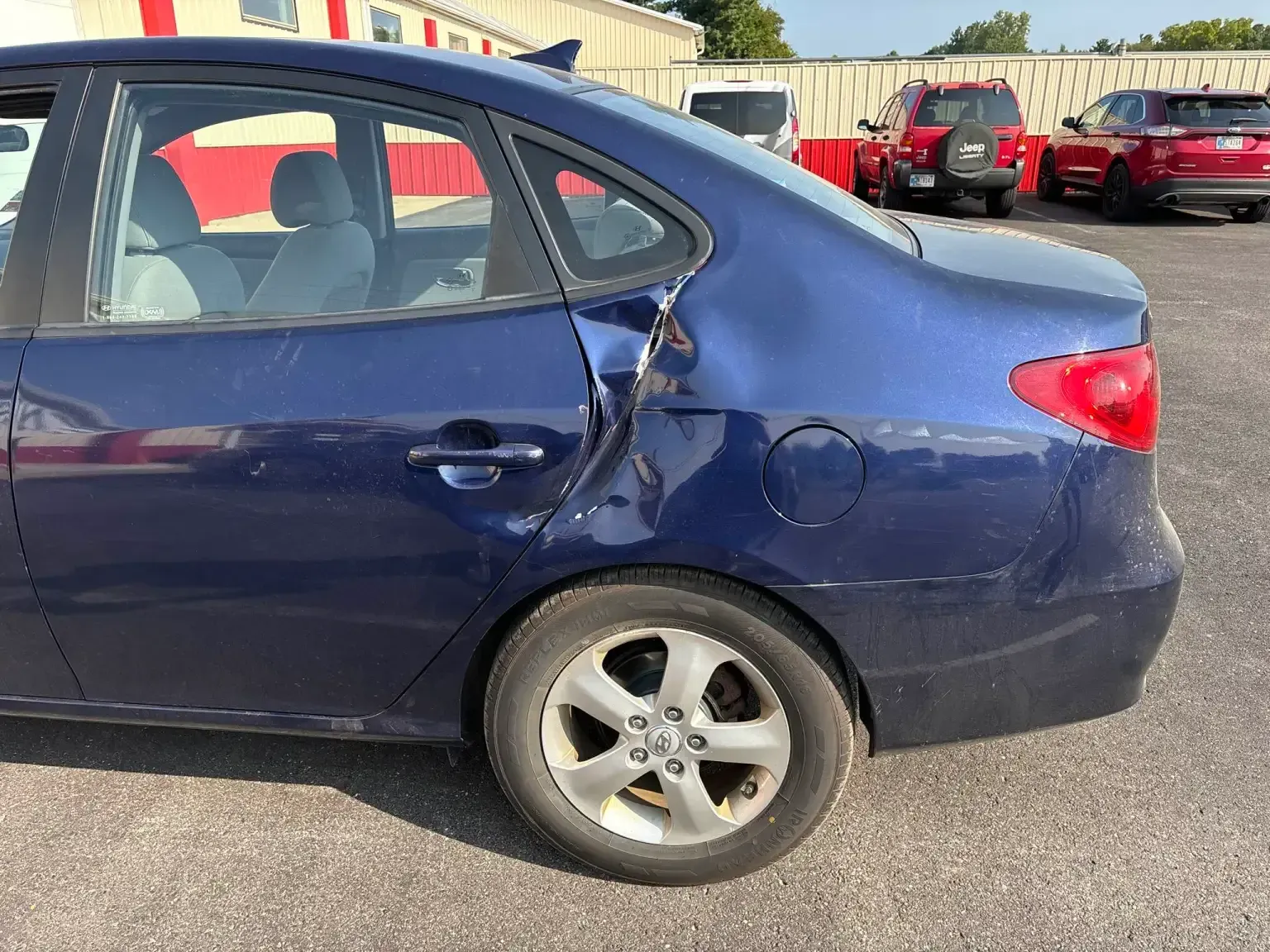 Blue pickup truck parked on asphalt. Black and silver rim.