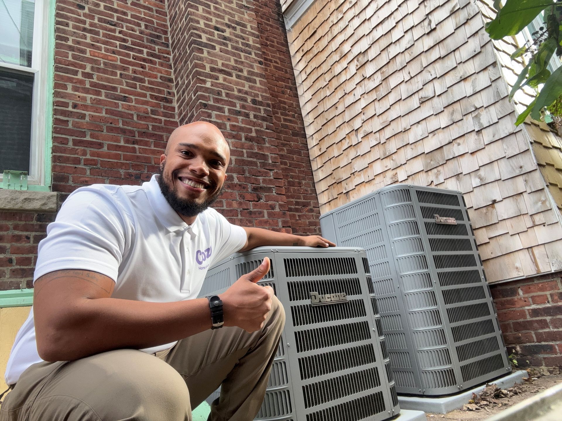 Outdoor air conditioning unit on a concrete pad, near a tan house.