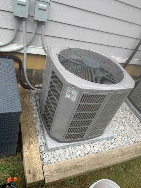 Manifold gauge set connected to an air conditioning unit outdoors, checking pressure.